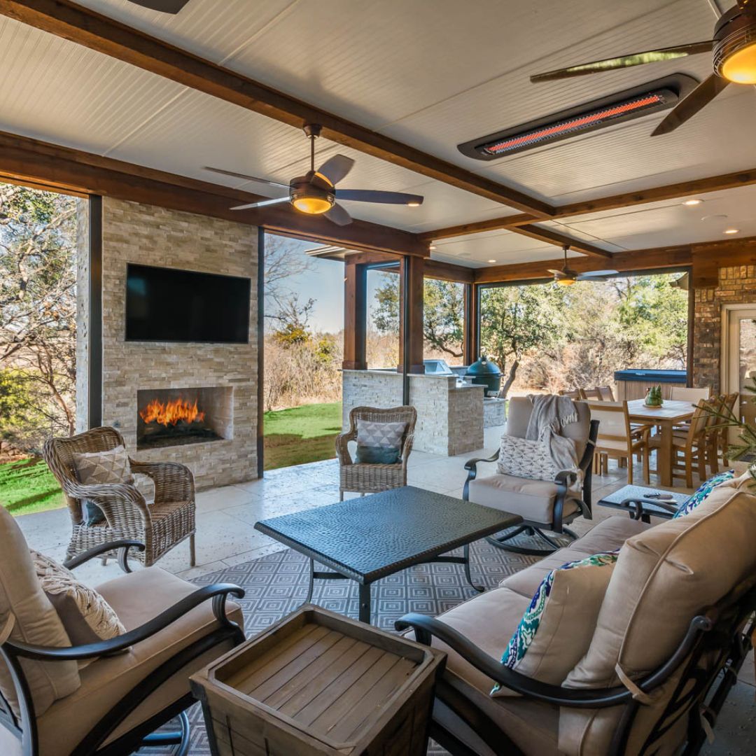 couches and a fireplace with a tv mounted on it outside