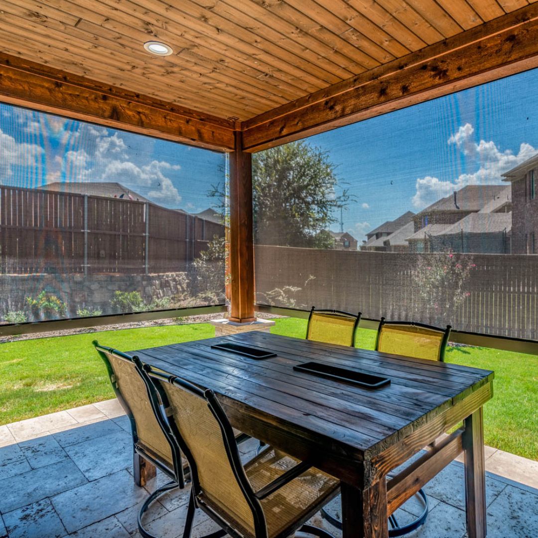 A patio with motorized screens halfway down, shading the sun
