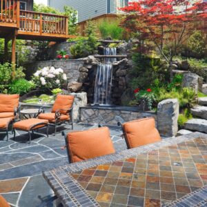 A beautiful patio with a water feature and lush greenery.