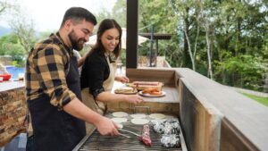 Man and woman cooking over grill