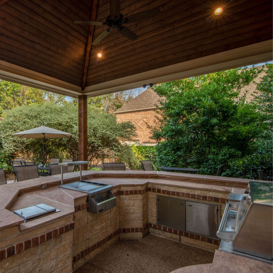 a beautiful outdoor kitchen with appliances that fit the design