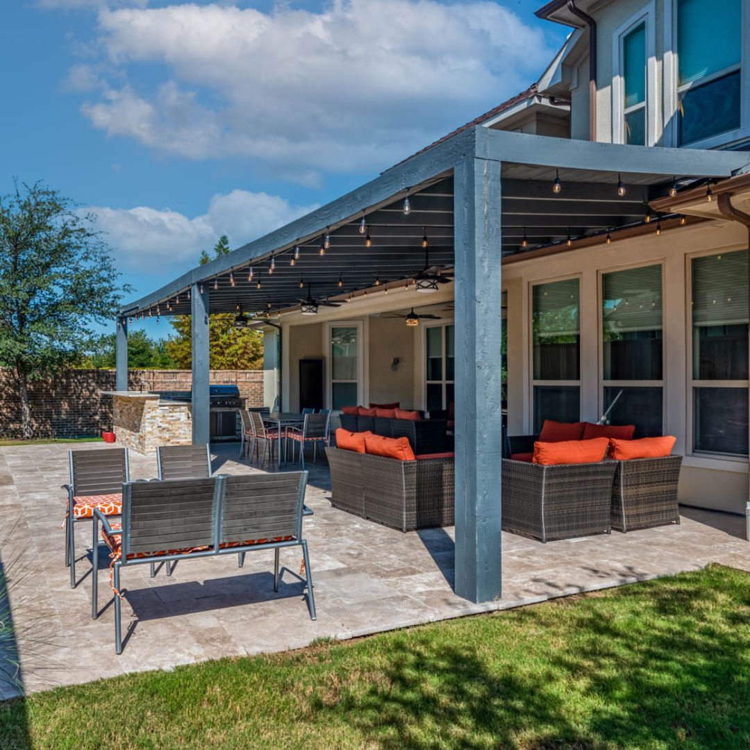 an outdoor living space with furniture under shade and in the sun