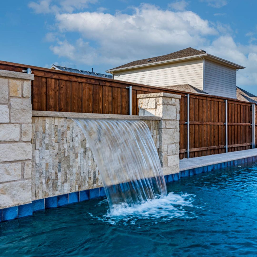 Close-up of a pool waterfall over a tile wall