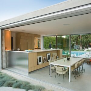 A nice covered outdoor kitchen with a bar and patio tables.