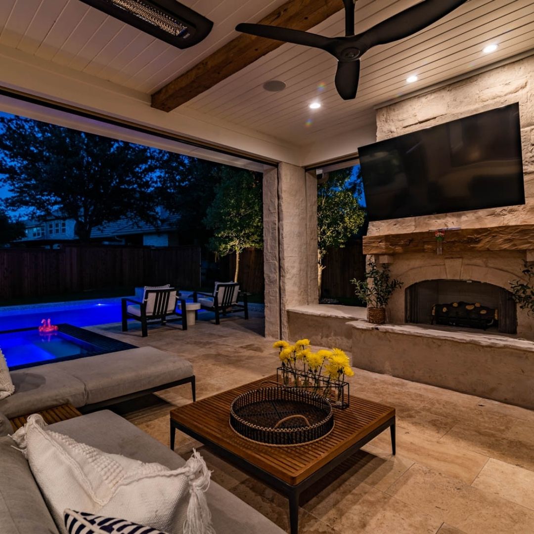 outdoor living space with a pool at night