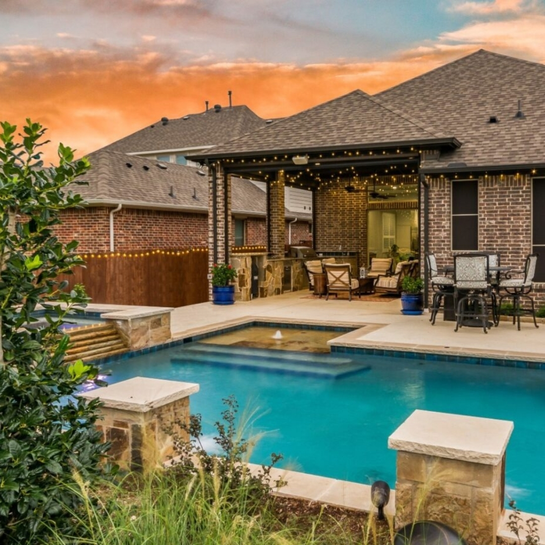 A blue residential pool and a pool house